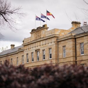 Photo of Parliament House exterior showing sandstone facade and flags flying, Hobart, 2022